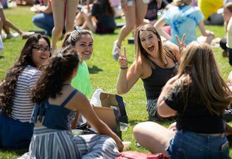 students sit in grass