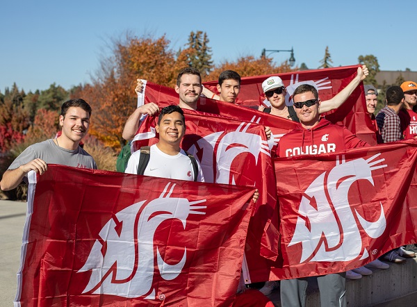 students hold flags with WSU logo